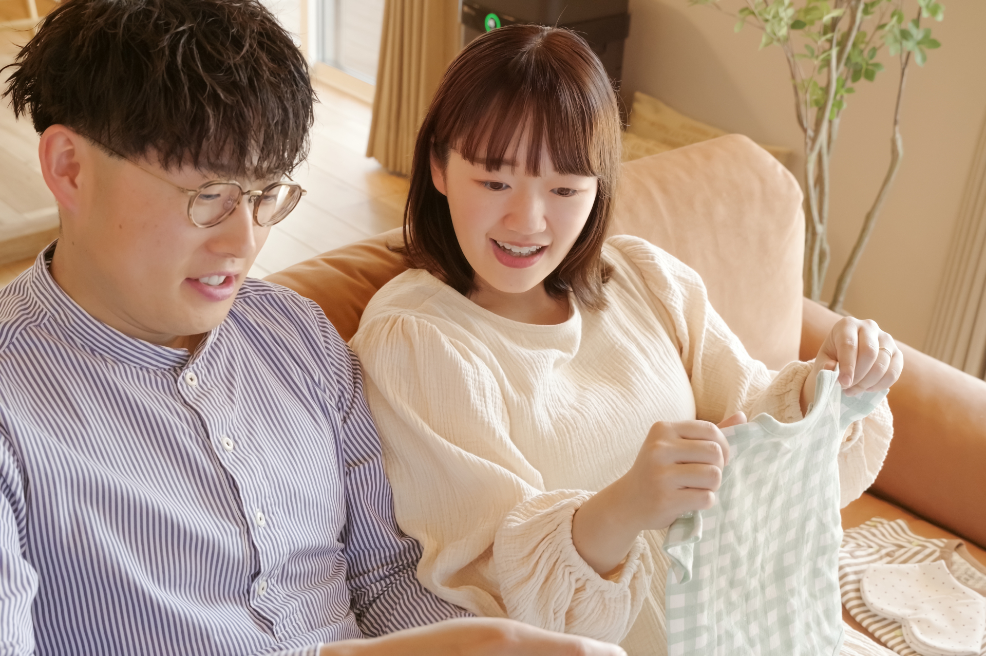 ベビー用品を手に喜ぶ夫婦画像