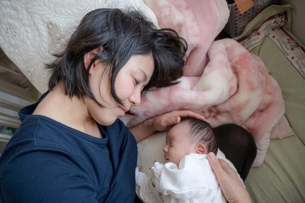 赤ちゃんに添い寝するママ